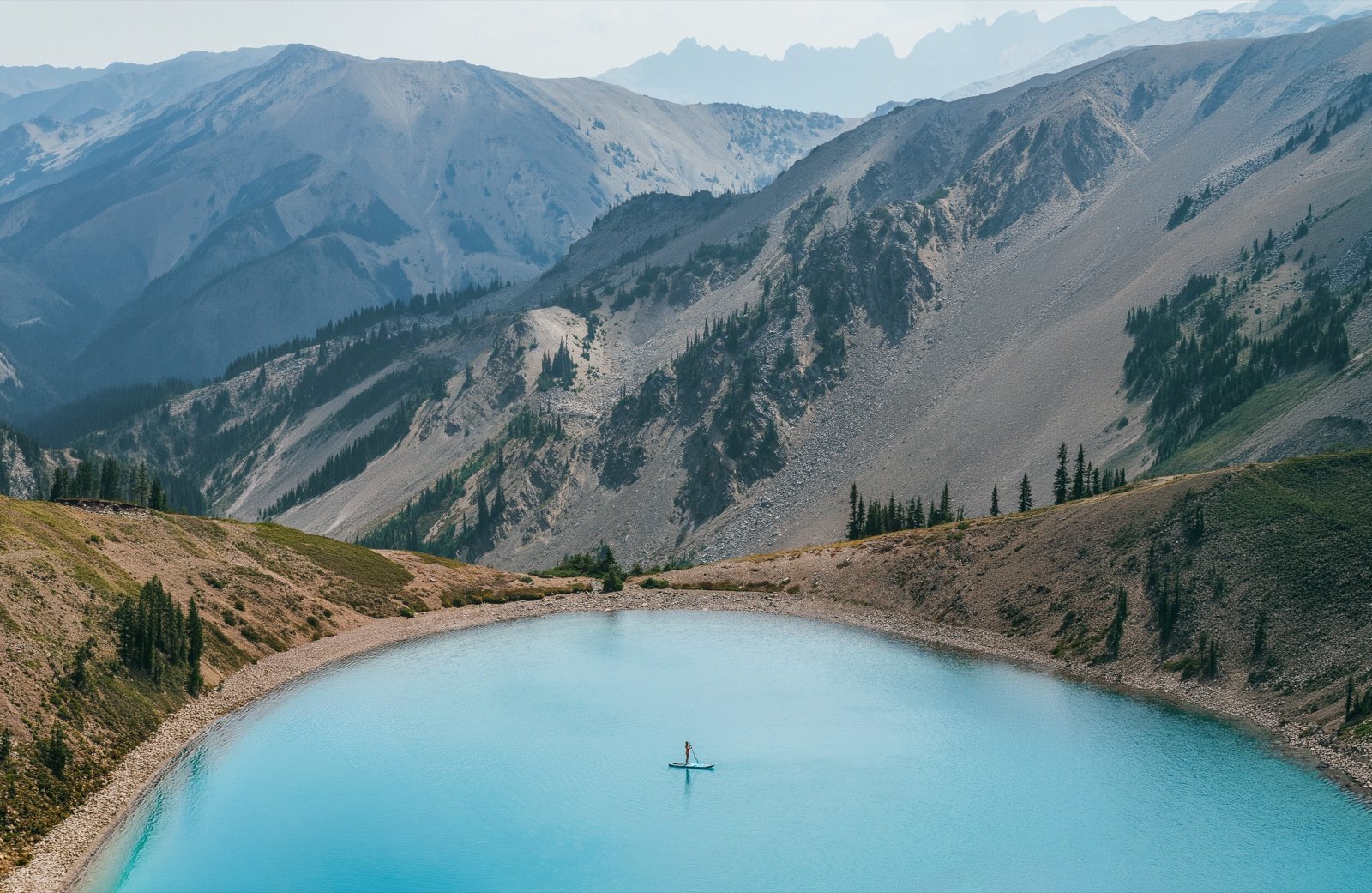 Paddleboarding on a turquoise alpine tarn in Olympic National Park